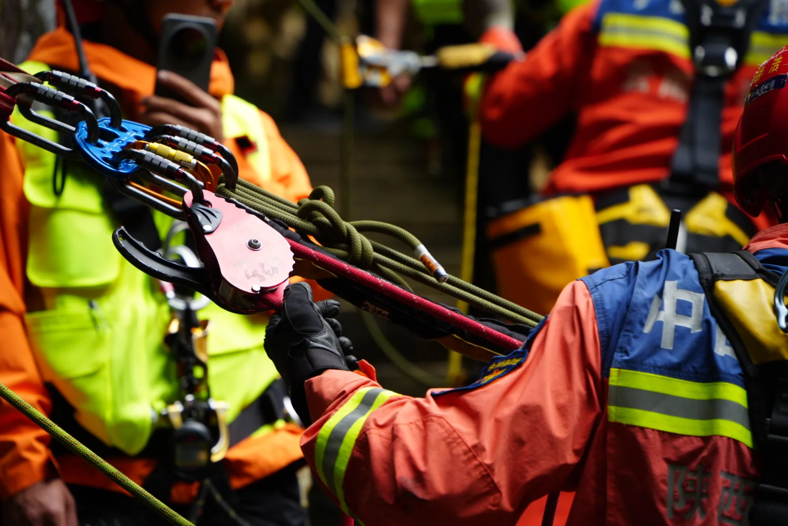 A rescue team member holding the rope at a red RD2 and rigging plate on the anchor